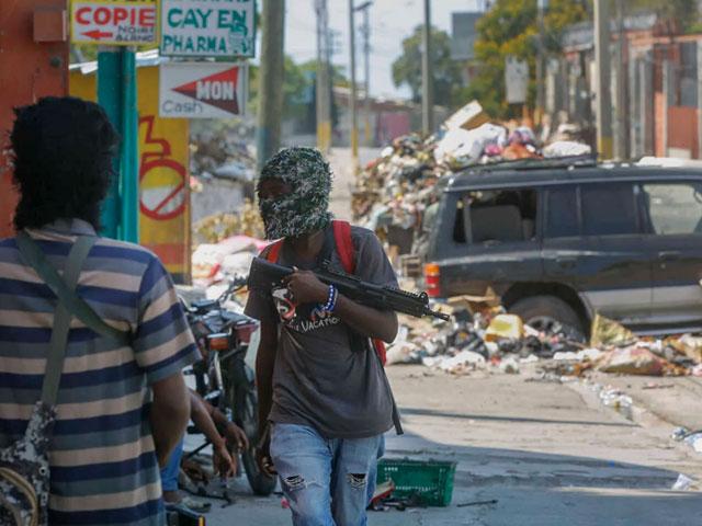 Armed members of the G9 and Family gang stand guard at their roadblock in the Delmas 6 neighborhood of Port-au-Prince, Haiti, March 11, 2024.  .(AP Photo/Odelyn Joseph, File)
