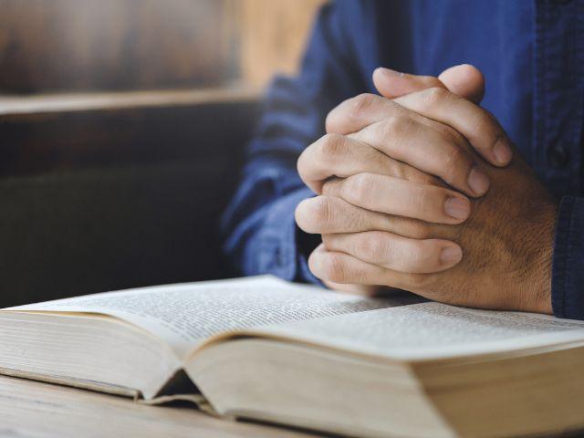 hands crossed on bible