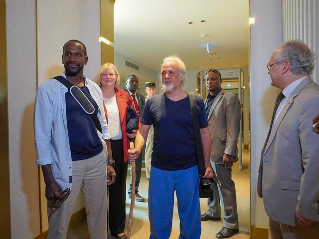 French journalist Olivier Dubois, left, and American aid worker Jeffery Woodke, center, arrive at the VIP lounge at the airport in Niamey, Niger, Monday March 20, 2023. (AP Photo/Judith Besnard)