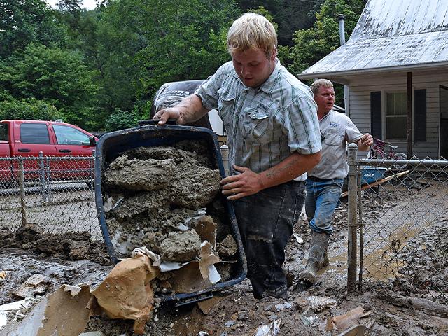 Volunteers from the local mennonite community clean flood damaged property from a house at Ogden Hollar in Hindman, Ky., Saturday, July 30, 2022. (AP Photo/Timothy D. Easley)
