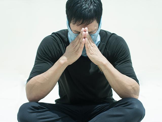 Man praying in surgical mask