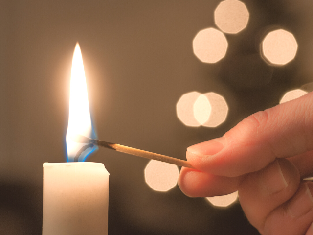 lighting a candle using a wooden match stick