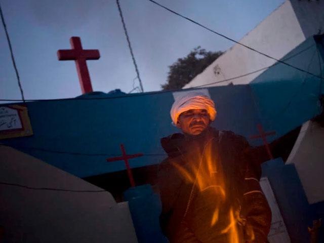 A Pakistani Christian man warms himself up in front of a church in a Christian community in Islamabad in 2008. (AP Photo/Emilio Morenatti)