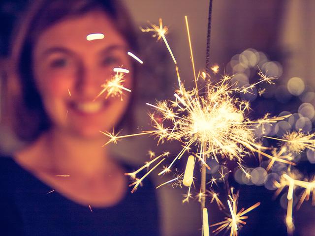 Happy woman holding sparkler