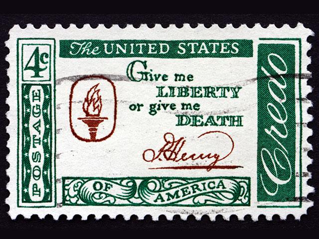 A U.S. postage stamp from 1961 says "Give Me Liberty or Give Me Death" by Patrick Henry (Adobe stock image)