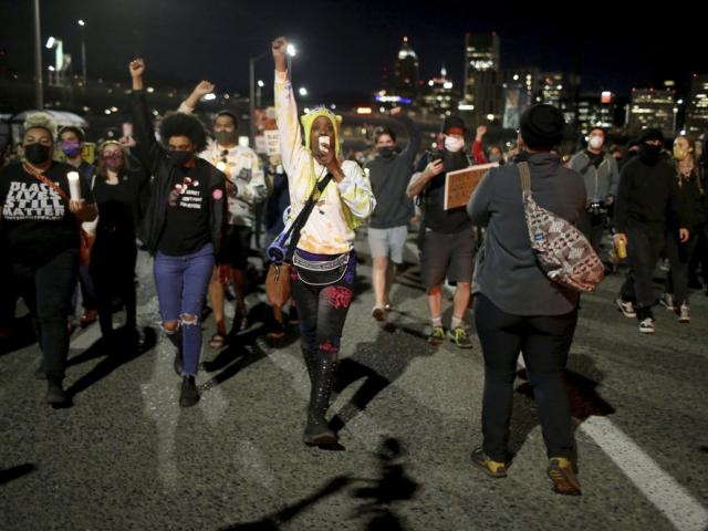 A group marches on Friday, April 16, 2021, in Portland, Ore. (Dave Killen/The Oregonian via AP)