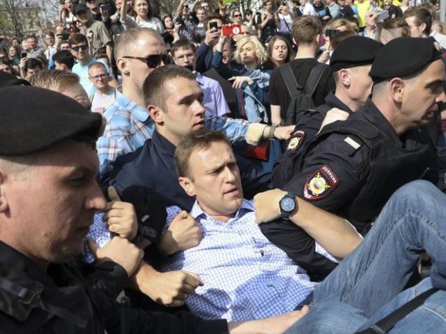 Russian police carry struggling opposition leader Alexi Navalny, center, at a demonstration against President Vladimir Putin in Pushkin Square in Moscow, Russia.