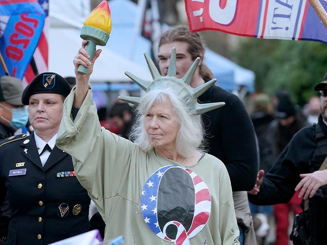 A person dressed as Lady Liberty wears a shirt with the letter Q, referring to QAnon, as protesters take part in a protest, Wednesday, Jan. 6, 2021, at the Capitol in Olympia, Wash.,