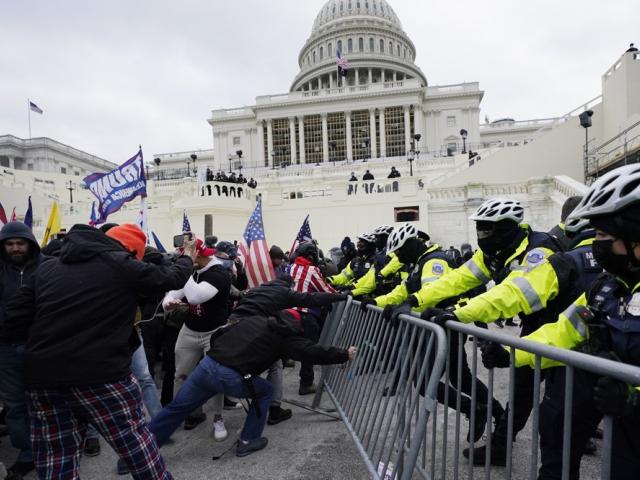 People try to break through a police barrier, Wednesday, Jan. 6, 2021, at the Capitol in Washington (AP Photo/Julio Cortez)