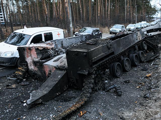 Cars drive past a destroyed Russian tank as a convoy of vehicles evacuating civilians leaves Irpin, on the outskirts of Kyiv, Ukraine. (AP Photo/Vadim Ghirda)