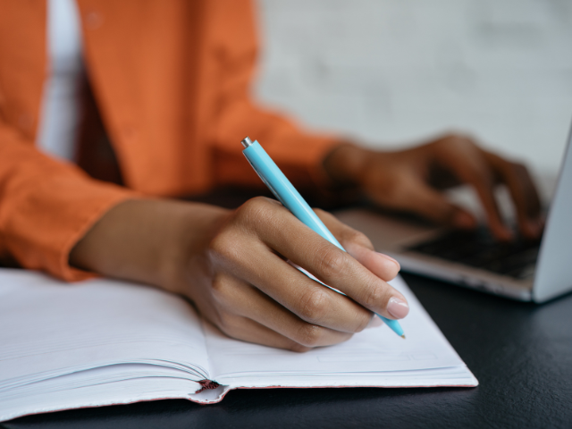 taking notes beside the laptop