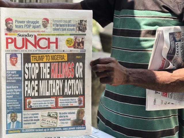 A vendor sells local newspapers with headlines referring to US President Donald Trump&#039;s comments about Nigeria, on the street of Lagos, Nigeria, Sunday, Nov. 2, 2025. (AP Photo/Sunday Alamba)