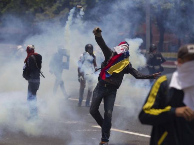 Opositores a Maduro se enfrentan con la policía en Caracas, Venezuela. Foto: AP / Ariana Cubillos