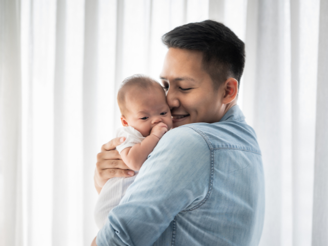 man holding baby on his shoulder