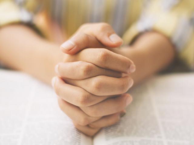 woman holding a Bible hands in prayer