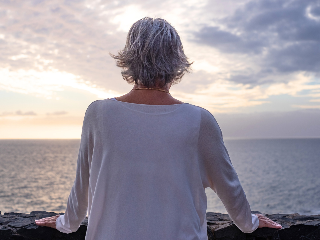 woman looking at sunrise on the ocean or bay