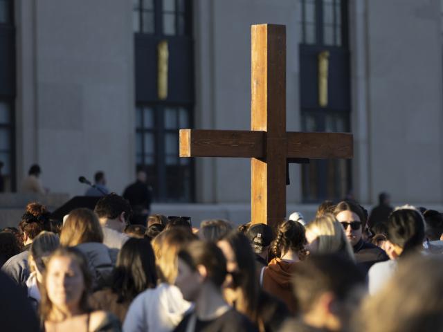 A cross stands above the crowd during a vigil held for victims of The Covenant School shooting on Wednesday, March 29, 2023, in Nashville, Tenn. (AP Photo/Wade Payne)
