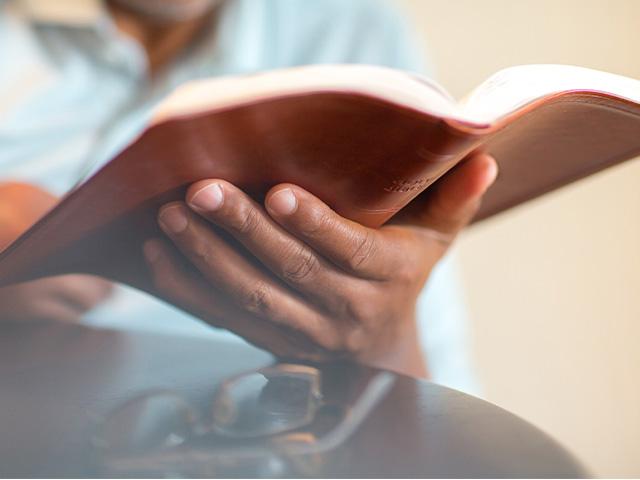 close up of an open Bible in a man