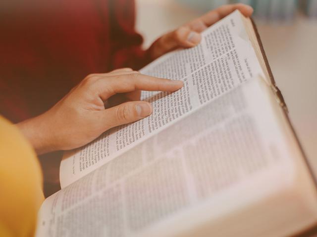 two people with open Bible reading Scripture together