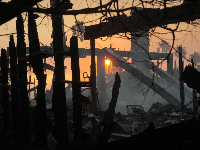 The sun rises and destruction from the Palisades Fire is seen in the Pacific Palisades neighborhood of Los Angeles, Thursday, Jan. 9, 2025. (AP Photo/Damian Dovarganes)