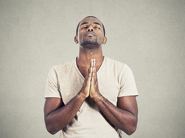 man praying eyes closed