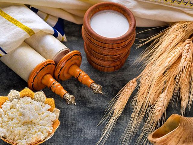 Symbols of Shavuot, a Torah, milk, cheese, wheat, and a shofar.