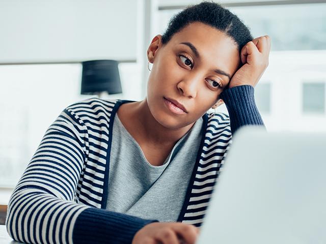 exhausted woman sitting with her laptop