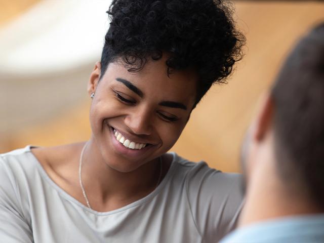 woman smiling while speaking with a male friend