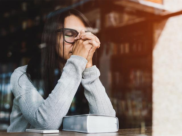 young woman praying looking distraught