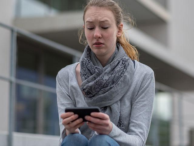 Young woman staring at smartphone