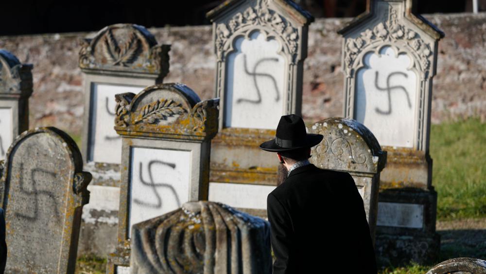 In this Dec. 4, 2019 file photo, Strasbourg chief Rabbi Harold Abraham Weill looks at vandalized tombs in the Jewish cemetery of Westhoffen in eastern France.  (AP Photo/Jean-Francois Badias, File)