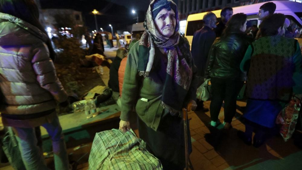 An ethnic Armenian woman from Nagorno-Karabakh carries her suitcase to a tent camp after arriving to Armenia&#039;s Goris in Syunik region, Armenia, Sept. 29, 2023. (AP Photo/Vasily Krestyaninov)