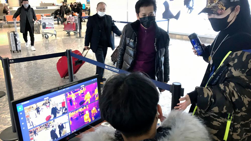 Travelers pass through a health screening checkpoint at Wuhan Tianhe International Airport in Wuhan in southern China&#039;s Hubei province, Tuesday, Jan. 21, 2020. (AP Photo/Emily Wang)