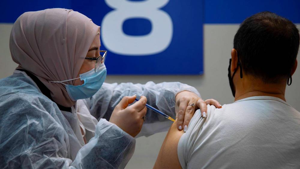 An Israeli man receives his second Pfizer-BioNTech COVID-19 vaccine from a medical professional. Wednesday, Jan. 20, 2021. (AP Photo/Oded Balilty)