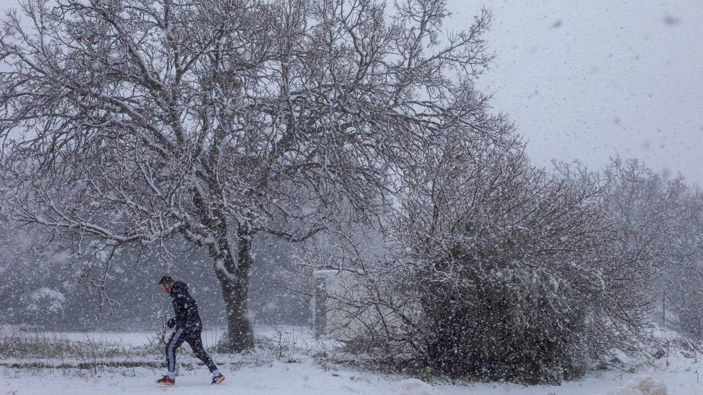 A man walks in the snow near the Quneitra border crossing between Syria and the Israeli-controlled Golan Heights Wednesday, Feb. 17, 2021. (AP Photo/Ariel Schalit)