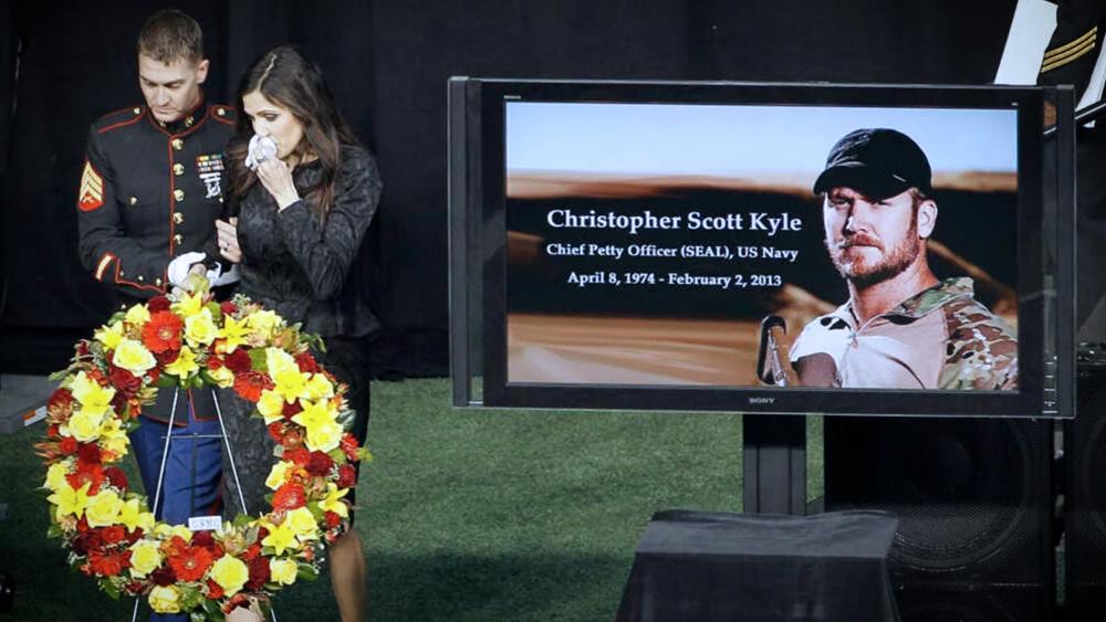 In this Feb. 11, 2013 file photo Christopher Kyle&#039;s wife, Taya, is escorted to her seat after memorializing her husband in Arlington, Texas. (AP Photo/Brandon Wade, File)