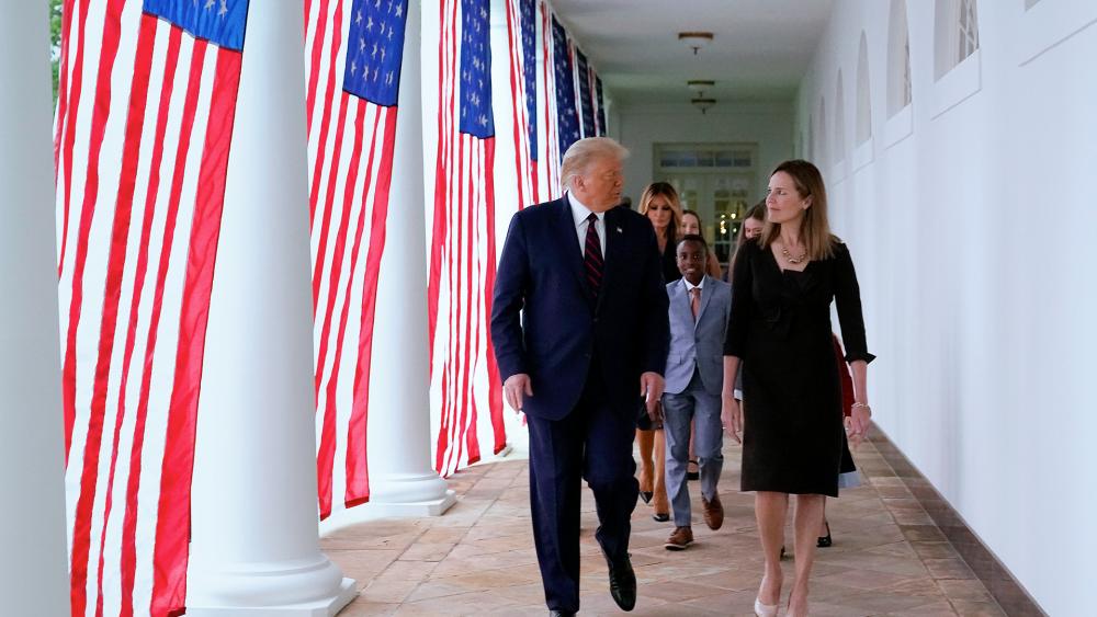 President Donald Trump walks along the White House Colonnade with Judge Amy Coney Barrett and her family, Sept. 26, 2020. (AP Photo/Alex Brandon)