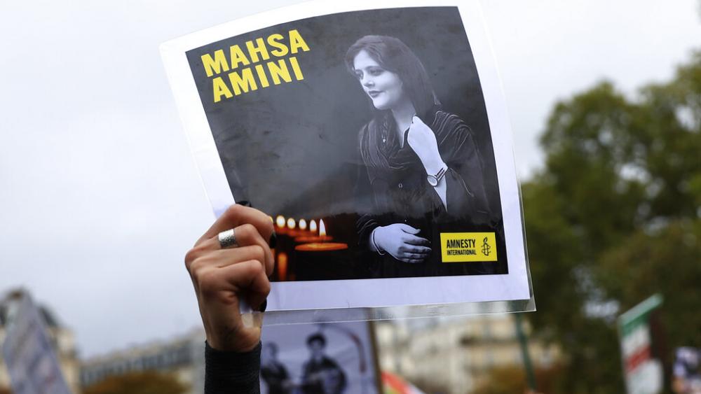 A Paris protestor shows a portrait of Mahsa Amini during a demonstration to support Iranian protesters standing up to their leadership.  (AP Photo/Aurelien Morissard)