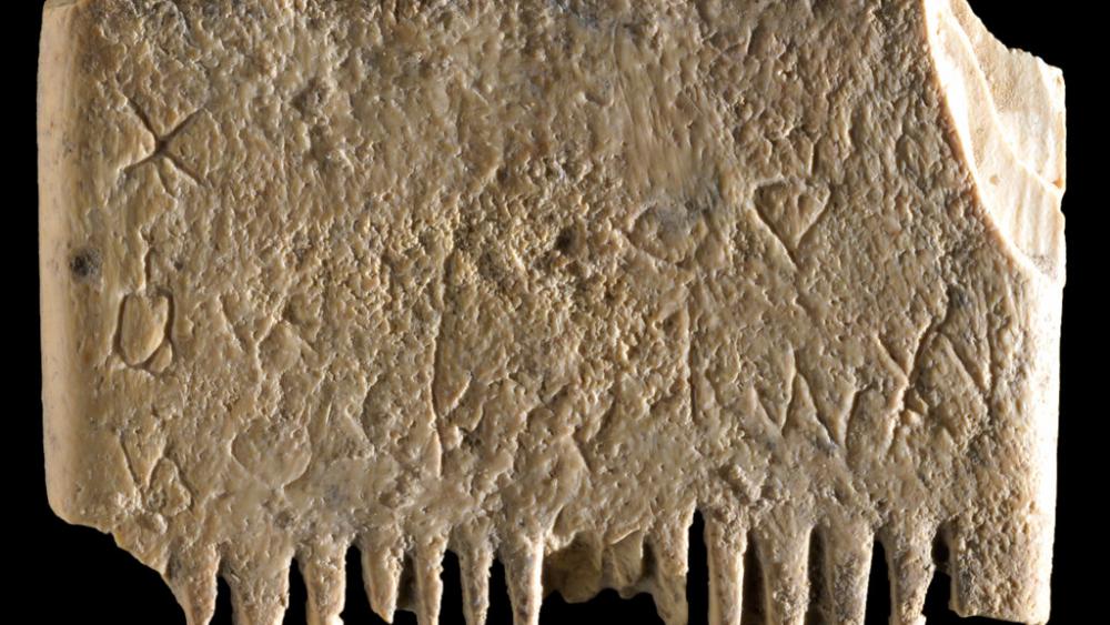 This undated image from Wednesday, Nov. 9, 2022, shows an ivory comb with an entire sentence in the Canaanite language, a 3,700-year-old inscription encouraging people to rid themselves of lice.(Dafna Gazit, Israel Antiquities Authority  via AP)
