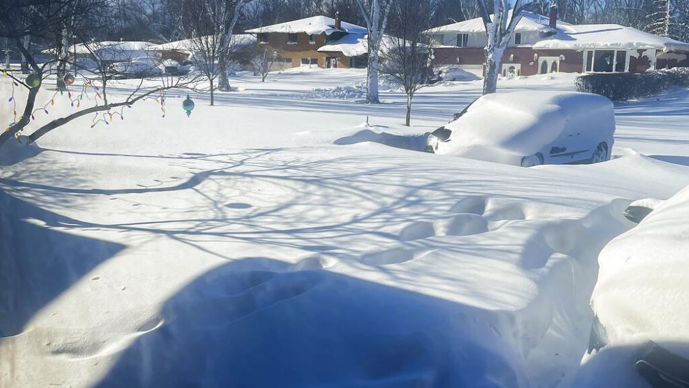 A car sits blanketed in snow on a driveway, Sunday, Dec. 25, 2022, in Amherst, N.Y. Millions of people hunkered down against a deep freeze Sunday morning to ride out the frigid storm. (AP Photo/Delia Thompson)