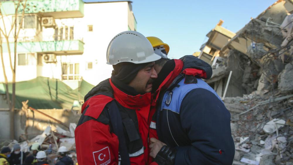 Rescuers weep by a collapsed building in Adiyaman, southern Turkey, Thursday, Feb. 9, 2023. ( AP Photo/Emrah Gurel)