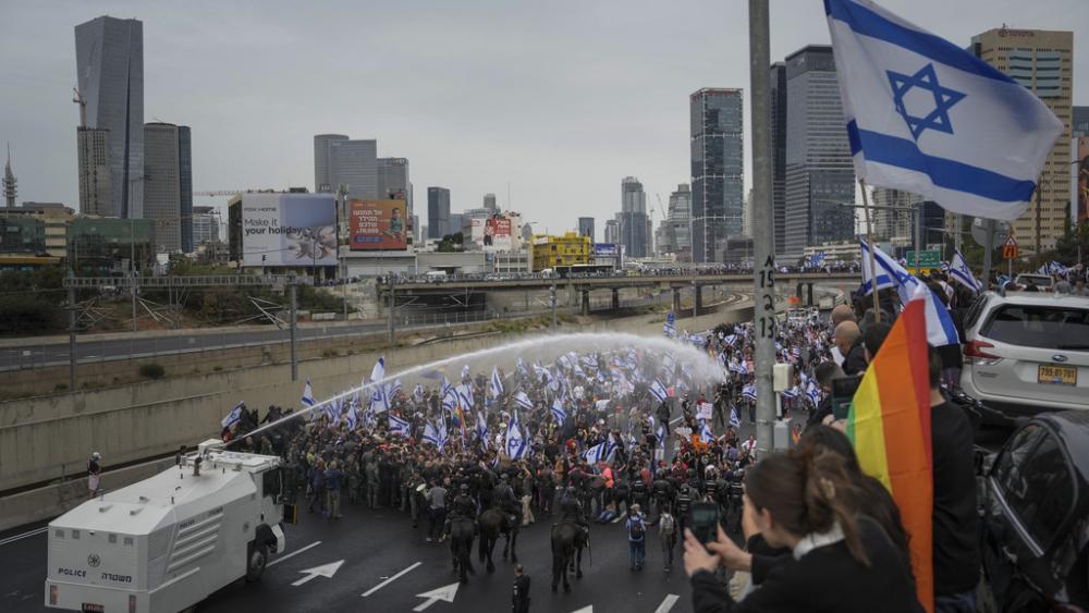 Israeli police use a water cannon to disperse Israelis blocking the freeway during a protest against plans by Prime Minister Benjamin Netanyahu&#039;s government to overhaul the judicial system in Tel Aviv, Thursday, March 23, 2023. (AP Photo/Oded Balilty)