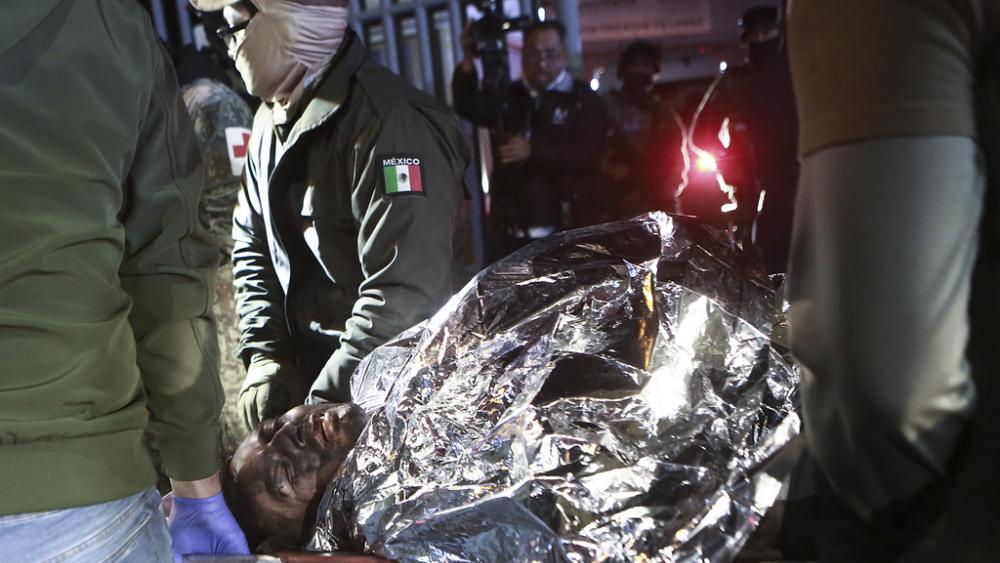 Paramedics carry a migrant who was wounded in a deadly fire at an immigration detention center in Ciudad Juarez, Mexico, Tuesday, March 28, 2023. (AP Photo/Christian Chavez)