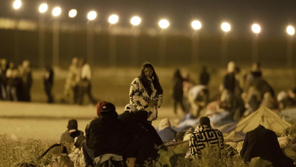 Migrants wait in the cold at a gate in the border fence after crossing from Ciudad Juarez, Mexico into El Paso, Texas, in the early hours of Thursday, May 11, 2023.  (AP Photo/Andres Leighton)