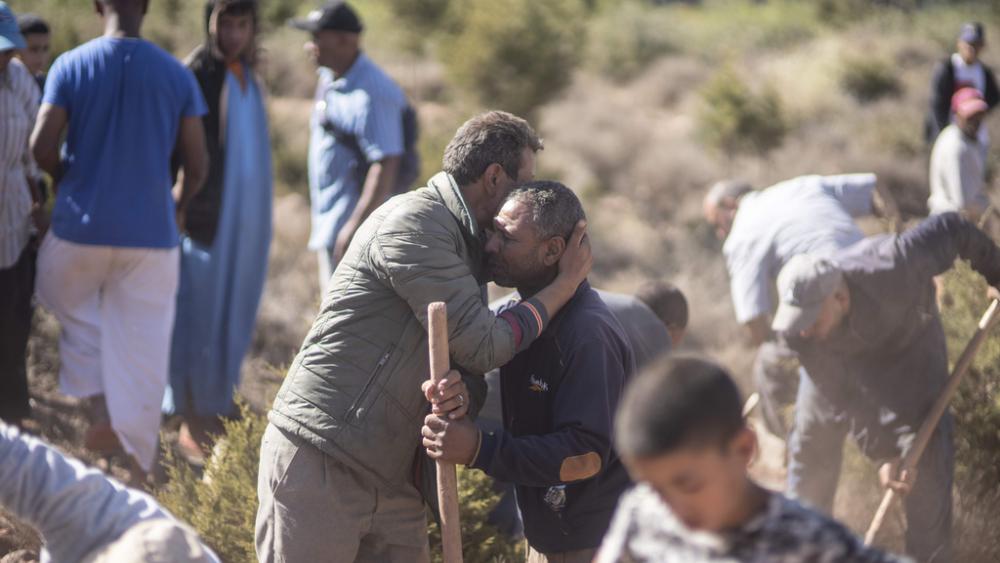 People comfort each other while digging graves for victims of the earthquake, in Ouargane village, near Marrakech, Morocco, Saturday, Sept. 9, 2023. (AP Photo/Mosa&#039;ab Elshamy)