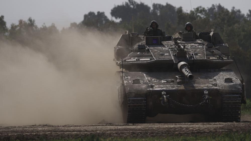 Israeli soldiers move on the top of a tank near the Israeli-Gaza border, as seen from southern Israel, Tuesday, Jan. 23, 2024. (AP Photo/Leo Correa)