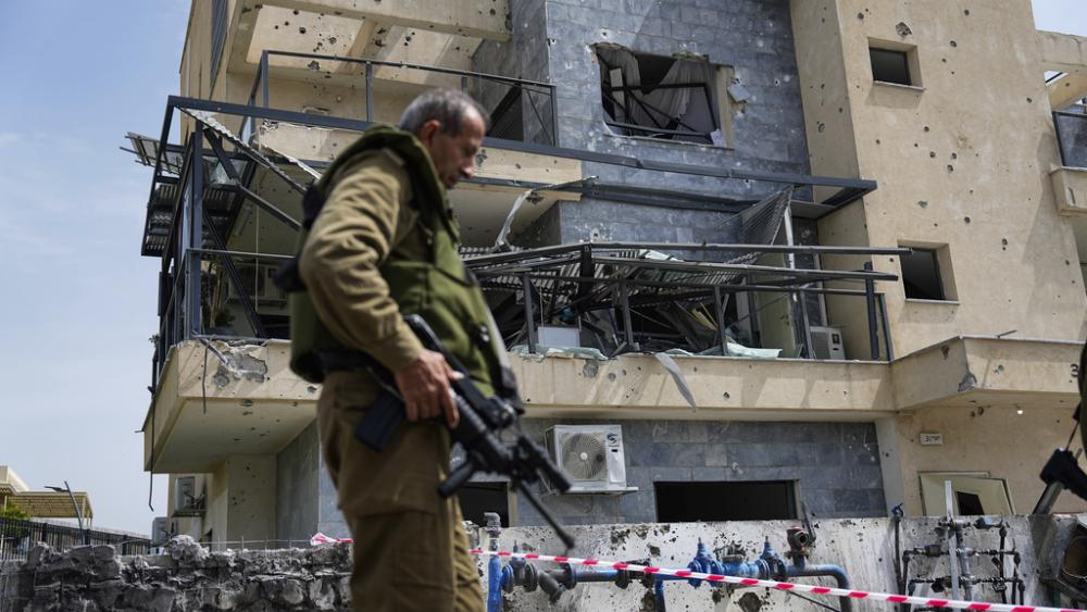 Israeli security forces examine the site hit by a rocket fired from Lebanon, in Kiryat Shmona, northern Israel, Wednesday, March 27, 2024. (AP Photo/Ariel Schalit)