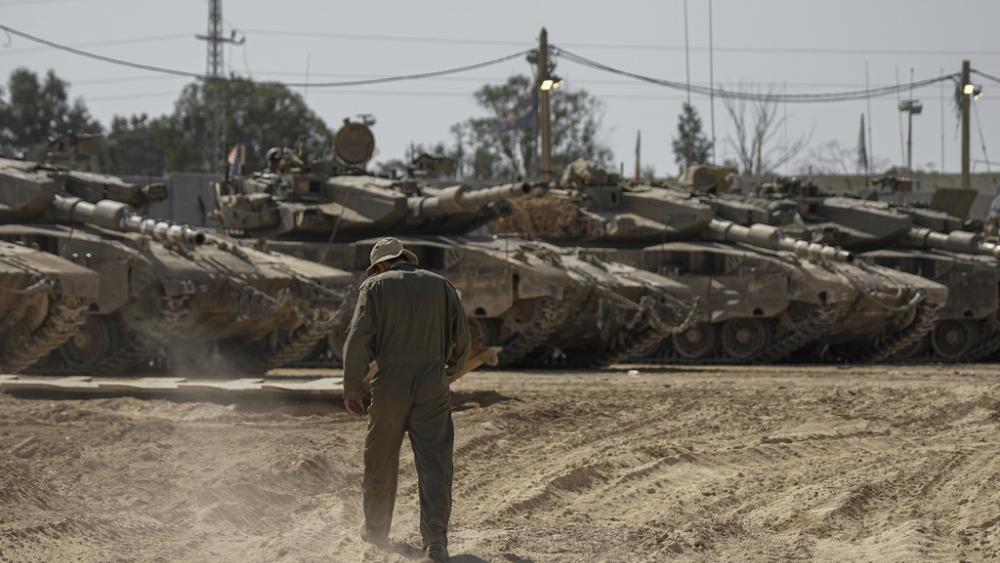 Israeli soldiers work on tanks at a staging ground near the border with the Gaza Strip, in southern Israel, Thursday, April 11, 2024. (AP Photo/Tsafrir Abayov)