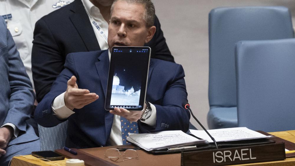 Israel’s U.N. Ambassador Gilad Erdan shows a video of Iranian missiles flying over Al-Aqsa Mosque as he addresses the United Nations Security Council, Sunday, April 14, 2024. (AP Photo/Yuki Iwamura)