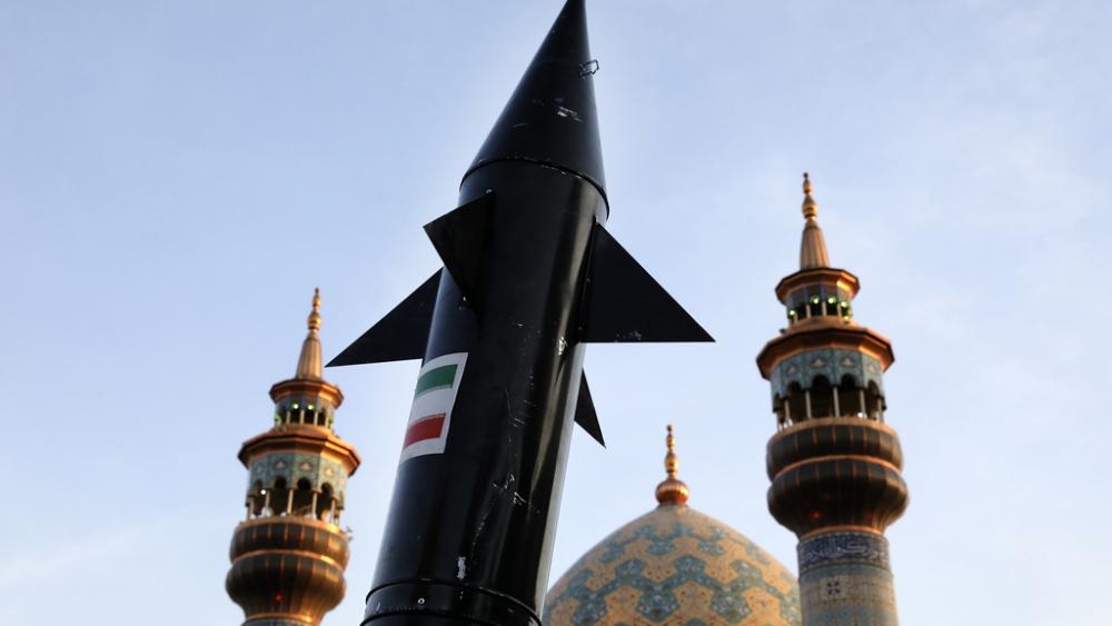 A model of a missile is carried by Iranian demonstrators as minarets and dome of a mosque is seen at background during an anti-Israeli gathering at the Felestin (Palestine) Sq. in Tehran, Iran, Monday, April 15, 2024. (AP Photo/Vahid Salemi)